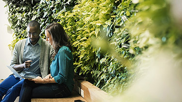 Image de deux personnes sur un banc entourées de verdure pour montrer que des pratiques environnementales, sociales et de gouvernance rigoureuses sont au cœur de l’approche commerciale d’EDC.
