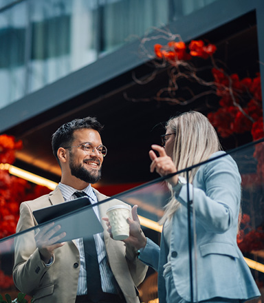Des collègues discutant du financement des affaires pour les exportateurs sur le balcon d'un bureau.