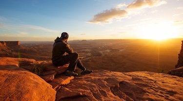 Un randonneur admire le coucher du soleil, Grand View Point, parc national Canyonlands, Utah, É.-U.