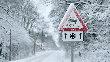 Road sign warns of slippery, snowy conditions ahead