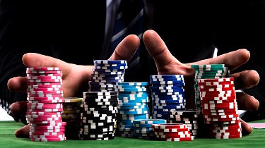 Poker chips stacked high on poker table represent precarious state of global economic, political situation