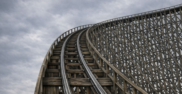 Wooden rollercoaster track stretches upward into a dark, gloomy sky.