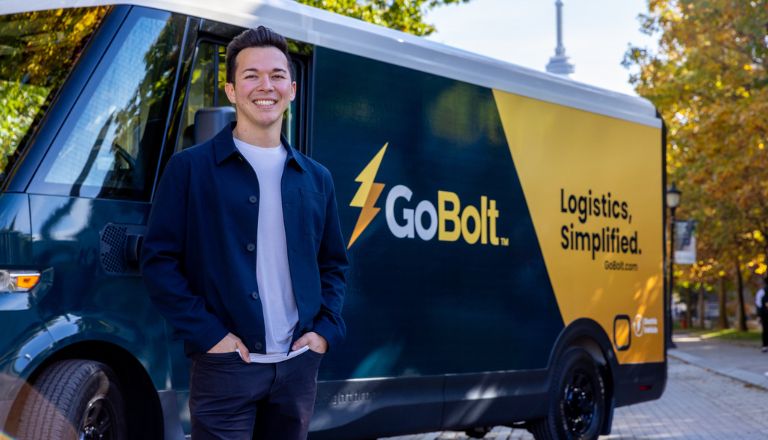 Mark Ang, co-founder of GoBolt, smiling in front of a truck with the GoBolt logo and slogan.