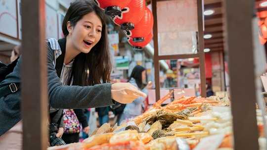 A woman buys fish at a market.