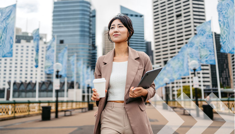 Young Asian Businesswoman Drinking Coffee To Go While Holding A Laptop In Darling Harbor In Sydney In Australia