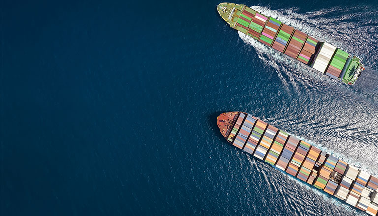 Vue aérienne de haut en bas de deux cargos porte-conteneurs voyageant en pleine mer.