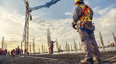 Construction worker oversees the pouring of concrete on a large-scale project.