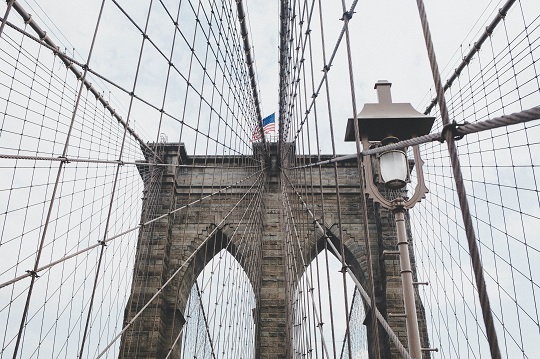 Closeup of the Brooklyn Bridge with the American flag