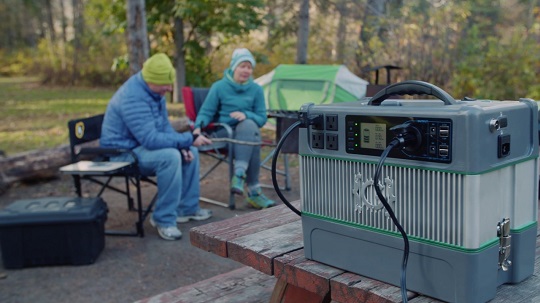 A couple uses a generator when camping.