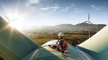 Image d'une personne assise au sommet d'une éolienne représentant les secteurs prioritaires pour bâtir une économie canadienne plus résiliente, durable et concurrentielle.