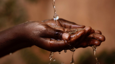 Mains sous de l’eau qui coule