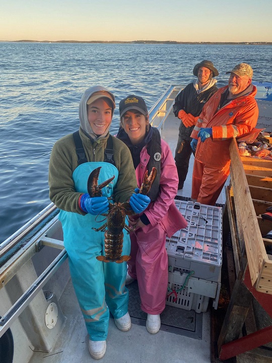 A smiling group of people on a fishing boat