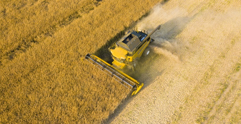 Farming machinery working in a large field.