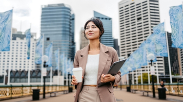 Un professionnel transportant un ordinateur portable dans un quartier des affaires, reflétant la confiance et la croissance des exportateurs. 