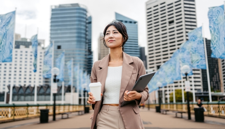 Business professional carrying laptop in an urban business district, reflecting exporter confidence and growth. 