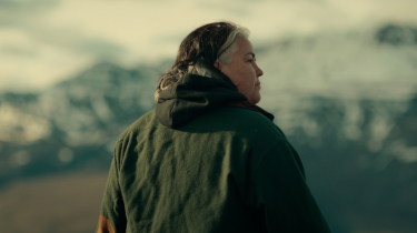 Woman standing in front of mountains representing resilience in global trade