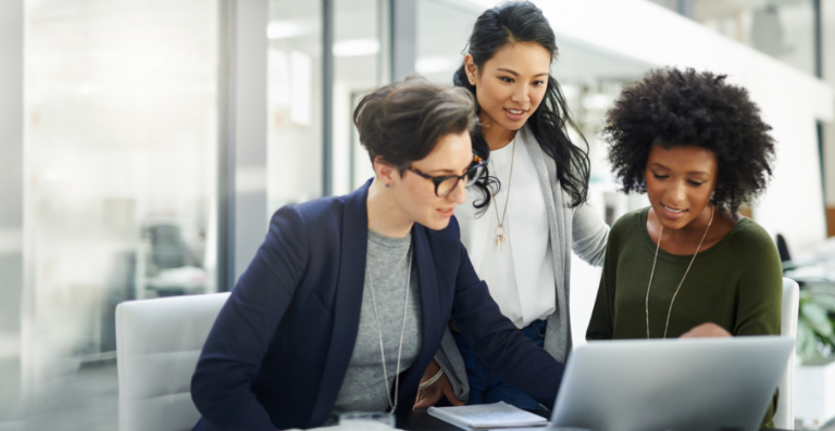 Three woman collaborating around a laptop