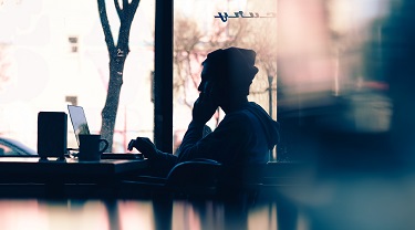 Man working in the shadows on his laptop