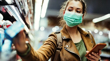 Femme portant un masque de protection à l’épicerie