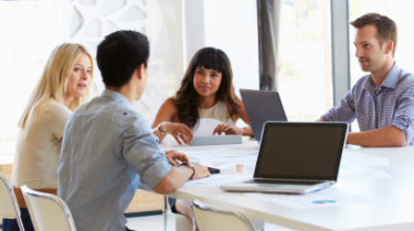 Groupe travaillant autour d’une table blanche