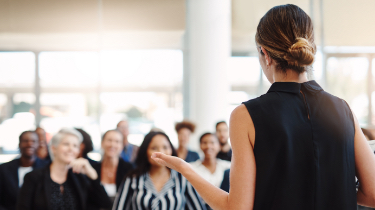 Woman in black sleeveless top facing crowd