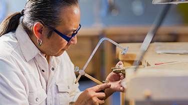 Indigenous jeweller working in his studio