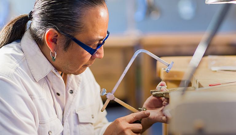 Indigenous jeweller working in his studio