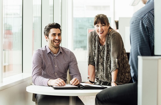 Des employés souriants d’EDC tiennent une réunion