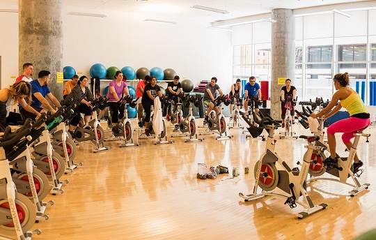 Des employés d’EDC suivent un cours de cardiovélo au centre de conditionnement physique de leur immeuble