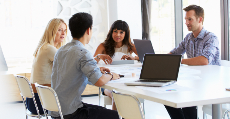 Groupe travaillant autour d’une table blanche