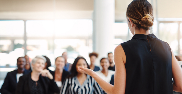 Woman in black sleeveless top facing crowd