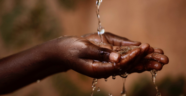 Mains sous de l’eau qui coule