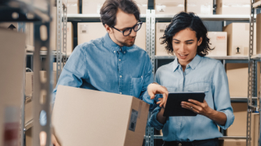 Man and woman checking clipboard in warehouse