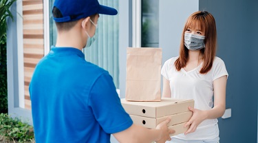 A woman accepts delivery of her online orders.