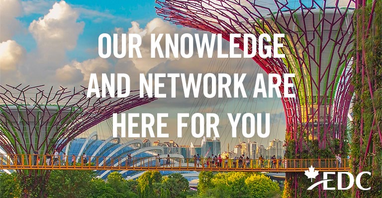 People stand on an elevated yellow footbridge at Gardens by the Bay in Singapore. 