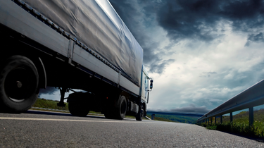 A truck on the road in a cloudy and dark landscape