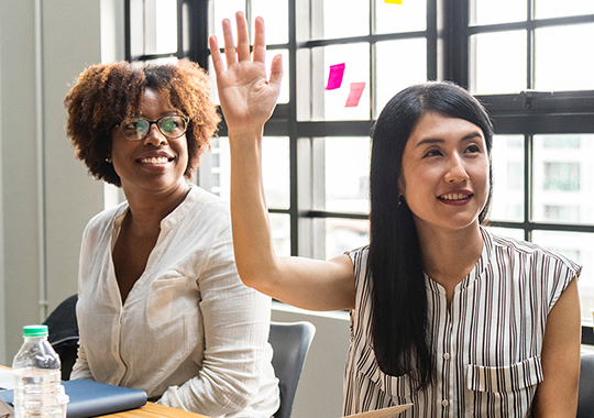 Businesswoman raising her hand at a meeting