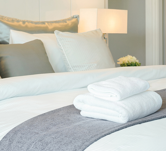 Folded towels sitting on top of bed linens