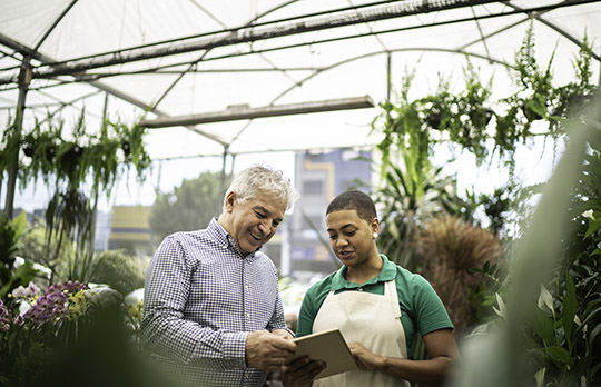 Image of two people in a greenhouse representing climate change and people