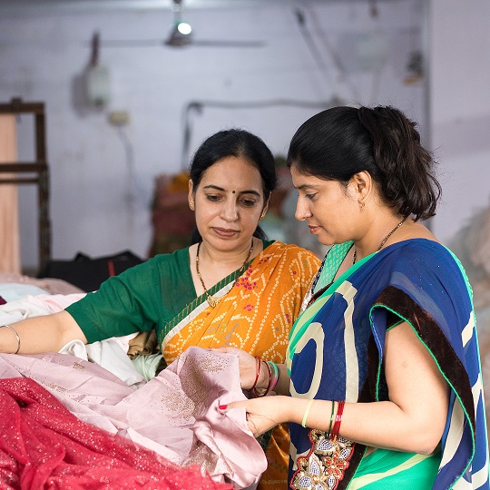 Two women picking out fabric in a garment factory