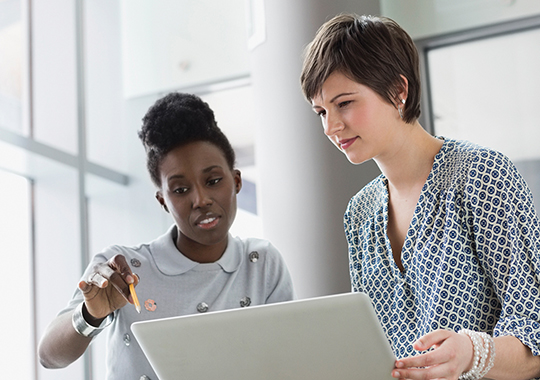 Femmes d’affaires utilisant un ordinateur portatif dans un bureau